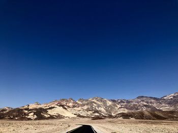 Scenic view of desert against clear blue sky