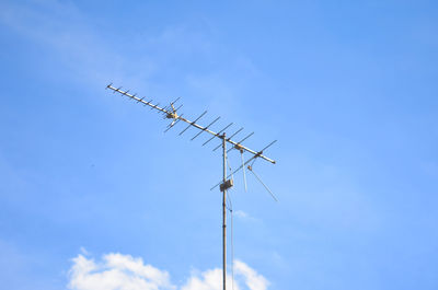 Low angle view of telephone pole against blue sky