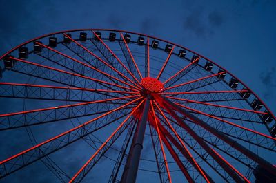 Low angle view of illuminated ferris wheel against sky at dusk