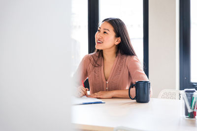 Smiling business professional listening in meeting at board room