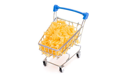 Close-up of small shopping cart against white background