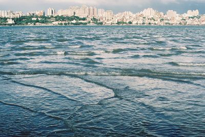 Scenic view of sea and buildings against sky