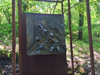 Metal sculpture by trees in forest