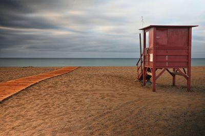 Lifeguard hut on beach against sky