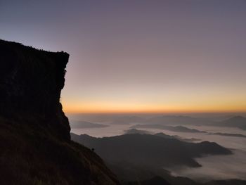 Scenic view of silhouette mountains against sky at sunset