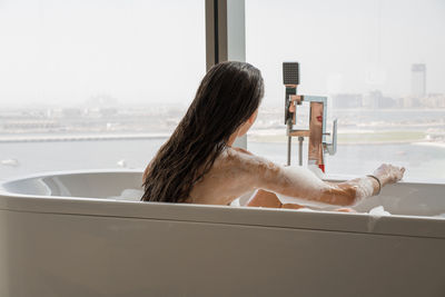 Portrait of woman wearing red lipstick relaxing in bath