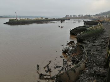 Abandoned ship on beach against sky