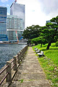 Footpath amidst buildings in city against sky