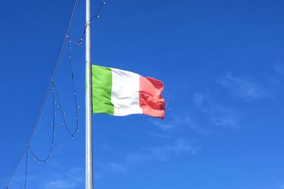 Low angle view of italian flag against blue sky