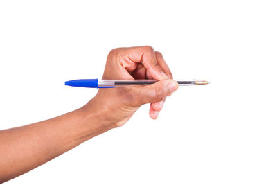 Close-up of human hand holding pen against white background