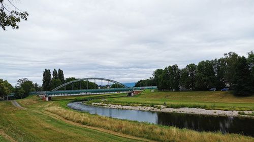 Arch bridge over river against sky