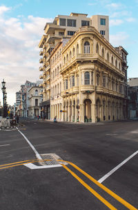 Road by building against sky in city