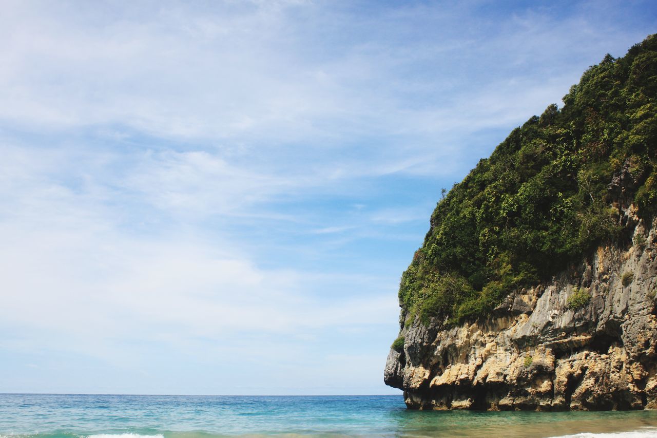 SCENIC VIEW OF ROCK FORMATION BY SEA AGAINST SKY