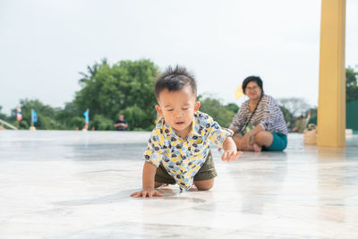 Rear view of couple looking at mother on floor