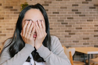 Portrait of a woman covering face