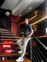 Portrait of young man standing on staircase