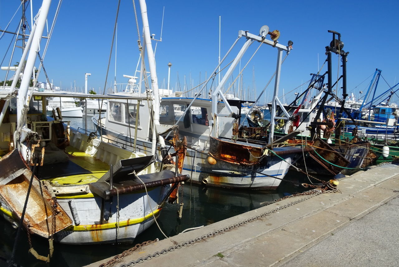 BOATS MOORED IN SEA AGAINST CLEAR SKY