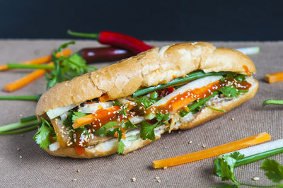 Close-up of sandwich and vegetables on table