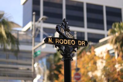 Low angle view of road sign against building