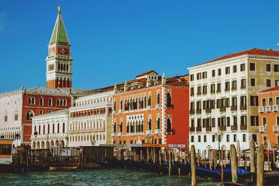 View of buildings in city against clear blue sky