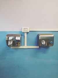 Close-up of telephone booth on table against wall