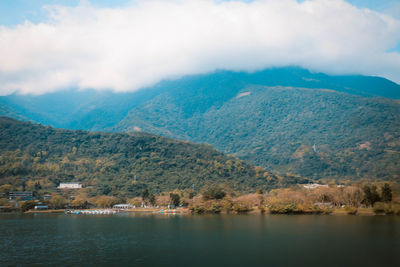 Scenic view of lake by mountains against sky