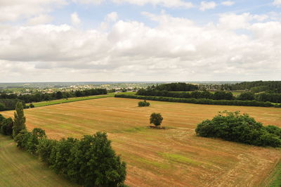 Scenic view of field against cloudy sky