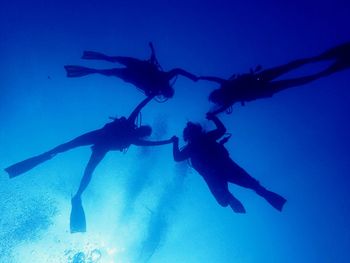 Low angle view of people swimming in sea