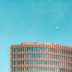 Low angle view of modern building against blue sky