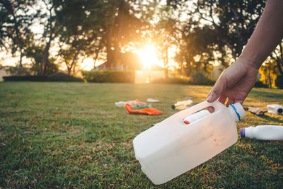 Woman hand on field at park during sunset