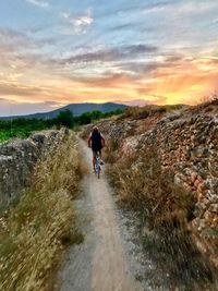 Man walking on mountain against sky