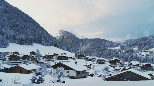 Houses in town against sky during winter