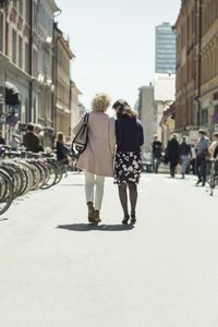 Full length rear view senior women walking on street