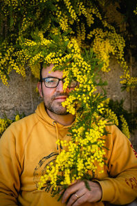 Portrait of woman holding yellow flower