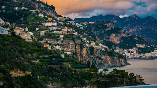 Scenic view of town by sea against sky