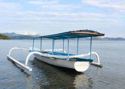 Boat moored on sea against sky