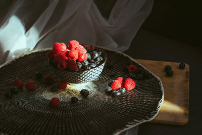 Little bowl with raspberries and blueberries, in a nice background.