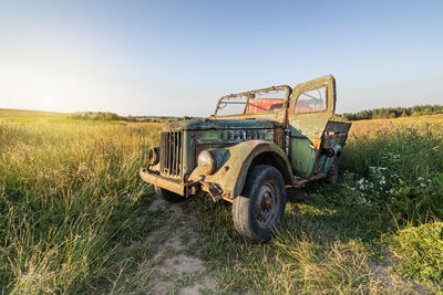 Abandoned vintage truck on field against clear sky