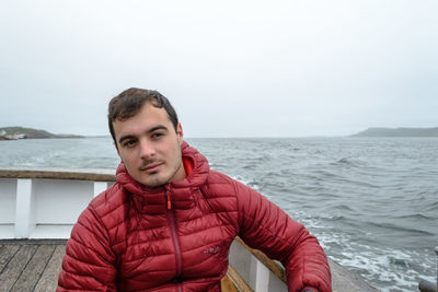 Portrait of young man against sea against sky