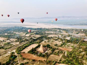 Hot air balloons flying over landscape