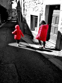 Red umbrella walking on footpath in front of street