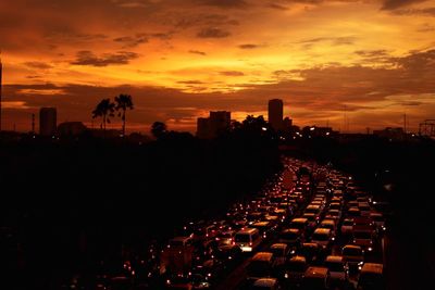 Vehicles on road along silhouette landscape