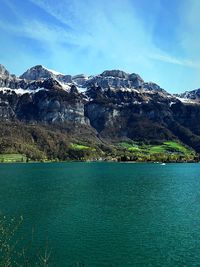 Scenic view of lake by mountains against sky