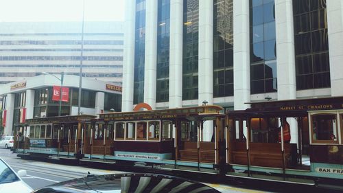 Train at railroad station in city against sky