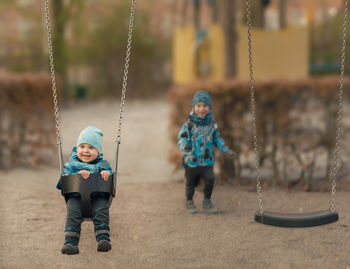 Full length of boy on swing at playground