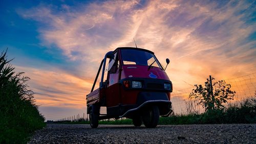 Vintage car on field against sky during sunset