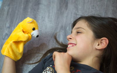 High angle view of girl playing with toy while lying on floor