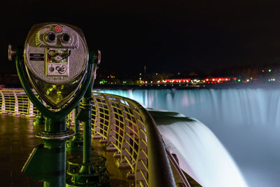 Close-up of illuminated city by river at night