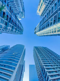 Low angle view of modern buildings against clear blue sky