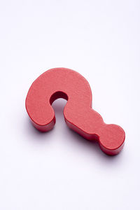 High angle view of red question mark against white background